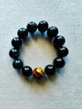 Pulsera de obsidiana negra con cuentas de 1,5 cm y pieza central de ojo de tigre de 1,8 cm