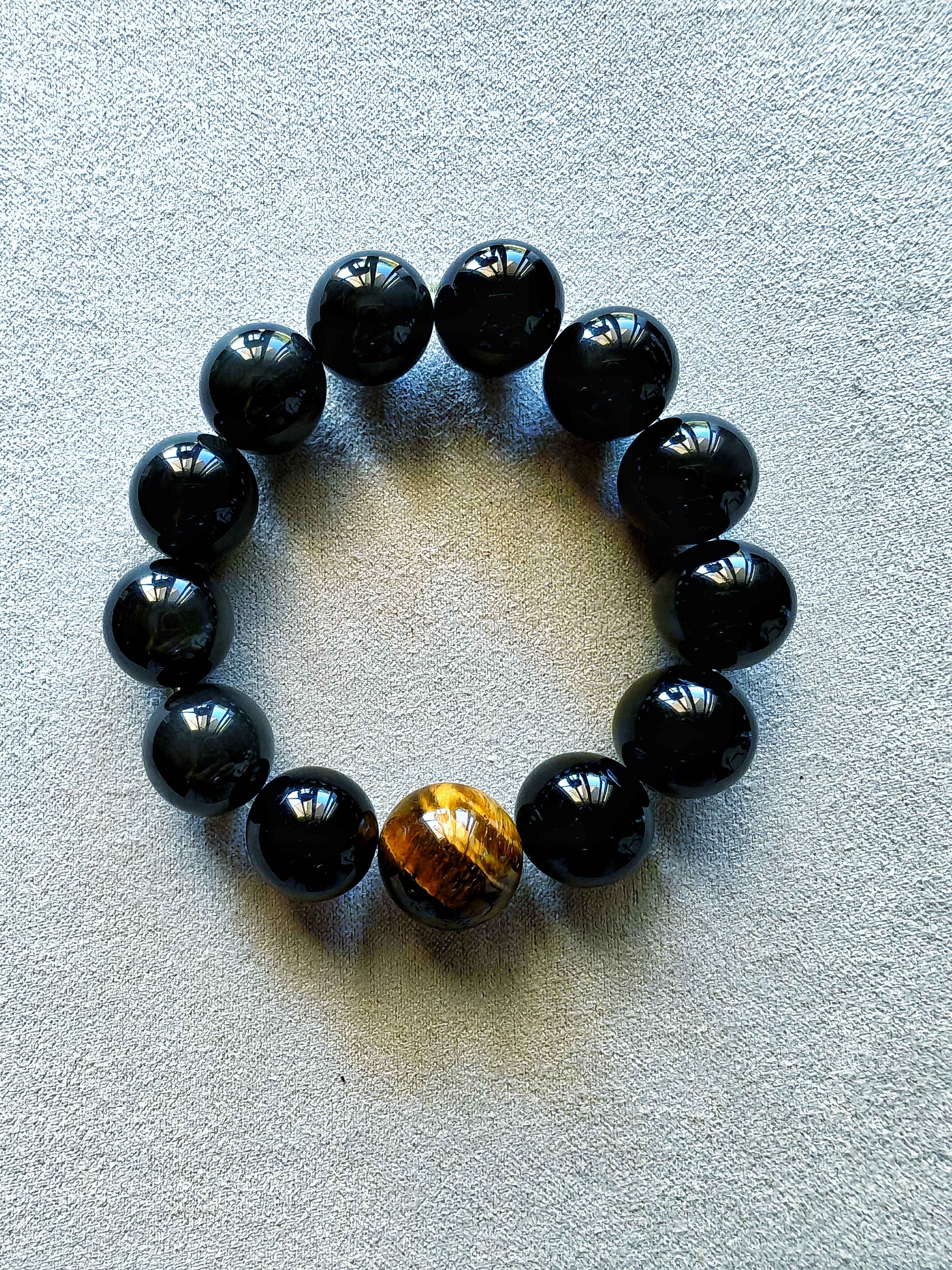 Pulsera de obsidiana negra con cuentas de 1,5 cm y pieza central de ojo de tigre de 1,8 cm