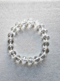 Pulsera de cuentas claras de cuarzo blanco facetado sobre fondo gris