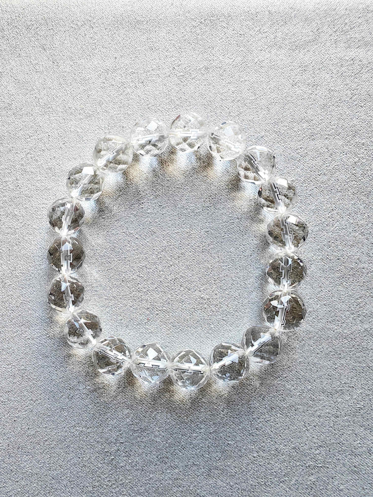 Pulsera de cuentas claras de cuarzo blanco facetado sobre fondo gris